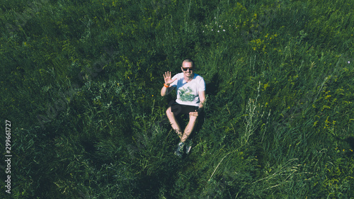 Top view aerial photo of freelancer man on the grass with laptop