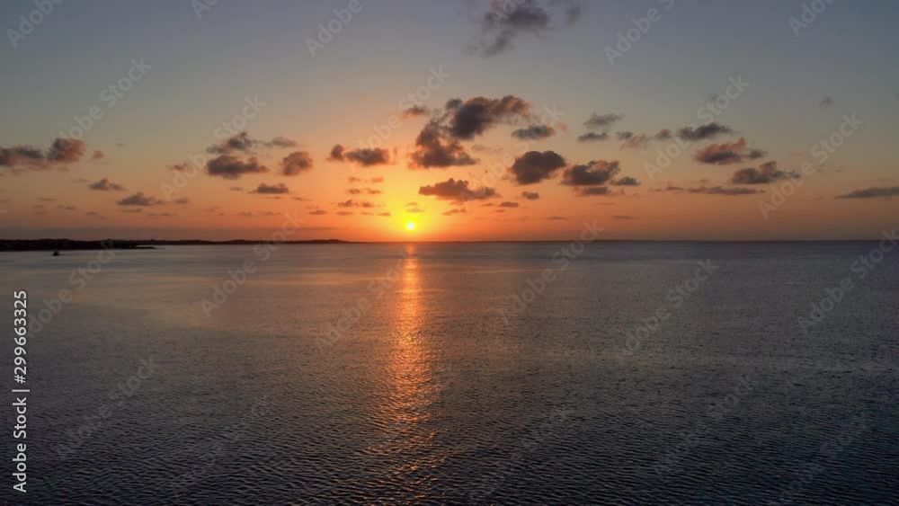 Aerial: Orange Sunset Over Rippling Water and Sun Rays Beaming Through Clouds - Providenciales, Turks and Caicos Aerial: Orange Sunset Over Rippling Water and Sun Rays Beaming Through Clouds - Providenciales, Turks and Caicos