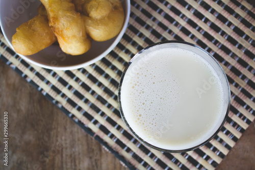 Soy milk in a glass and cup of fried cassava flour Resting on a brown wooden table. top view