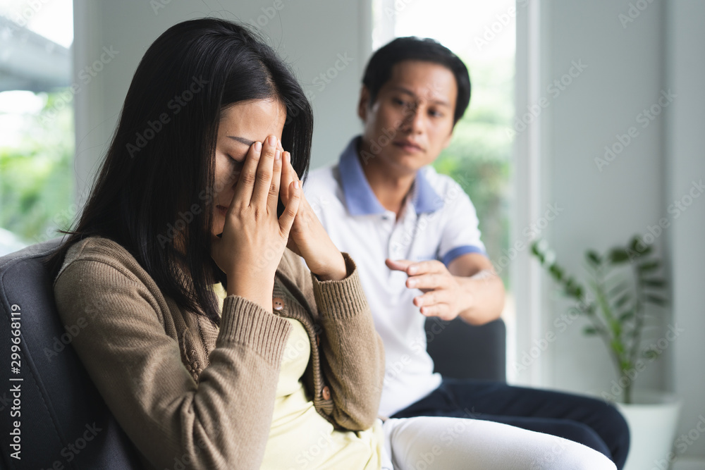 Asian couple having relation problem. Wife crying and sitting separate with her husband at home after quarrel. Asian couple having relation problem. Wife crying and sitting separate with her husband at home after quarrel.