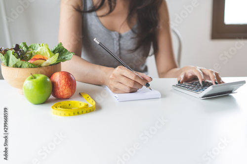 Woman calculating calories in her meal and taking note. photo