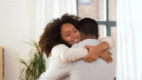 love, relationships and people concept - happy african american couple hugging at home photo