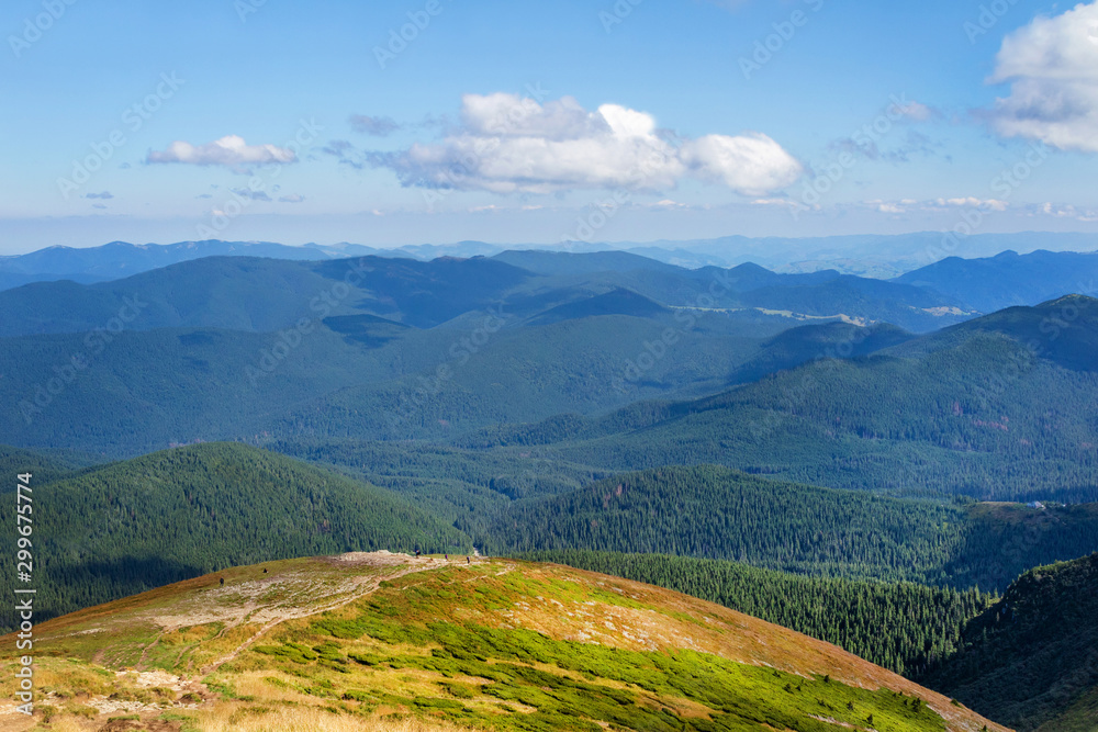 Naklejka premium Landscape photo of mountain hills with blue sunny day sky.
