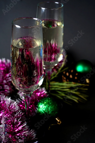Glasses with white wine and Christmas decorations on a gray background. Christmas and new year celebrations © ayuk1