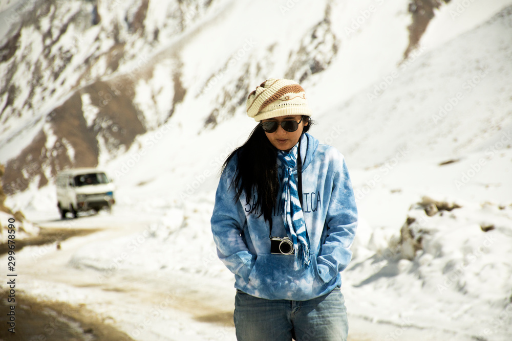 Travelers thai woman travel visit stand for take photo at Khardung La Road on top of himalaya mountain between go to Nubra valley village at Leh Ladakh while winter season in Jammu and Kashmir, India