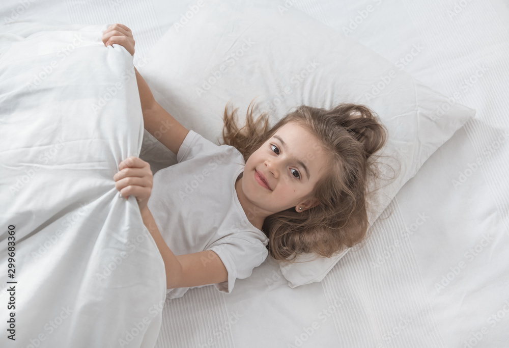 Cute little girl in bed woke up in the morning . Cute little girl in bed woke up in the morning .