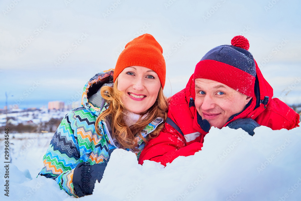 Happy pair of male and female in warm clothes together outside in field