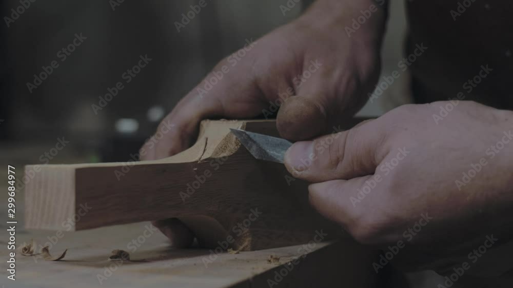 close-up of hands slicing a wooden product with a knife. a carpenter processes a wooden beam with a knife. 4k video. 59.94 fps close-up of hands slicing a wooden product with a knife. a carpenter processes a wooden beam with a knife. 4k video. 59.94 fps