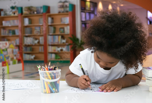 Little African girl painting and drawing with happiness.