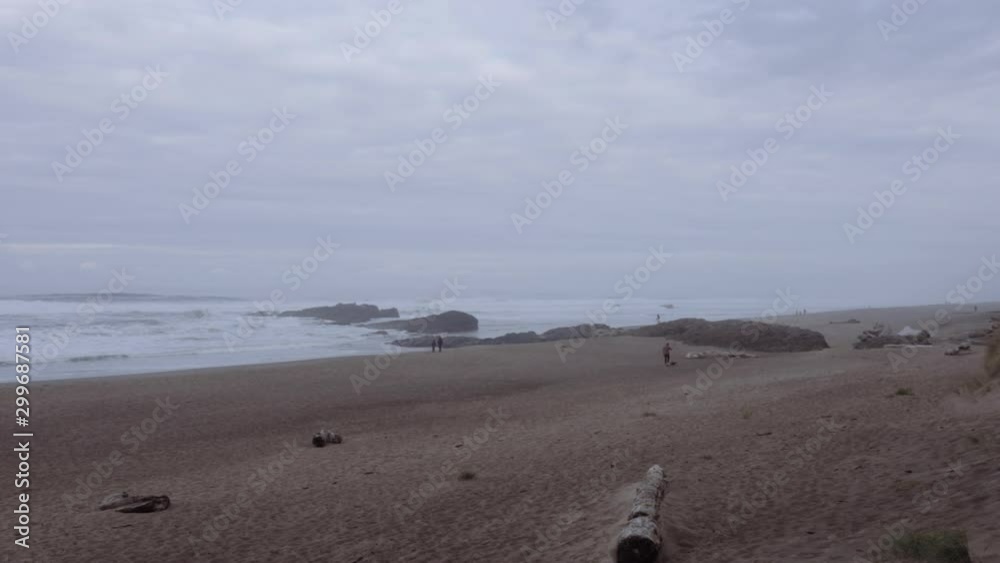 People in the distant walking along beach at dusk People in the distant walking along beach at dusk