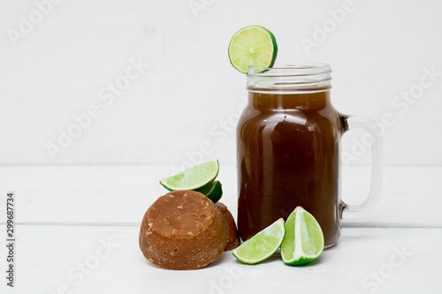 panela water with lemon on white wooden boards
