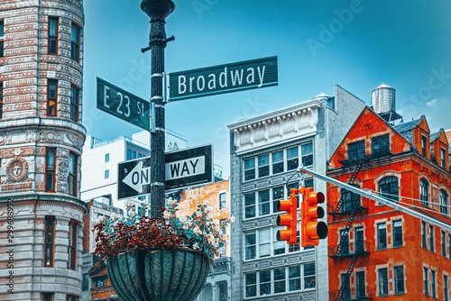 Street sign (nameplate) of Broadway and East 23 th Street and urban cityscape of New York. Midtown district. photo
