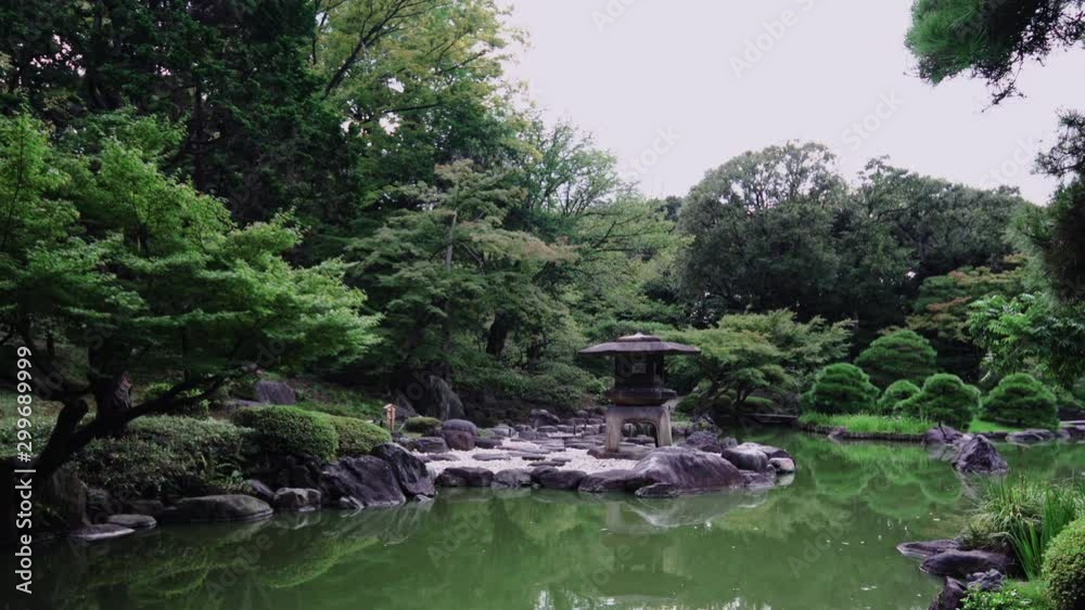Pan video of Tokyo Metropolitan Park KyuFurukawa's japanese garden's Yukimi stone lantern overlooking Shinji pond in summer. Pan video of Tokyo Metropolitan Park KyuFurukawa's japanese garden's Yukimi stone lantern overlooking Shinji pond in summer.