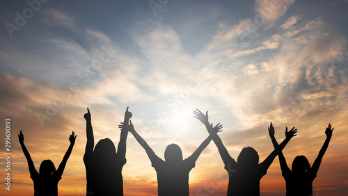 A group of people raised their hands freely and freely. With abstract sunset conceptual background