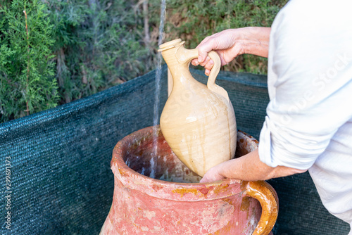 Mujer llena el cántaro de agua