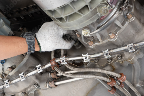 Gas turbine engine close up during maintenance when airplane park at the airport.Mechanic and technician repair hydraulic and check system of power plant.