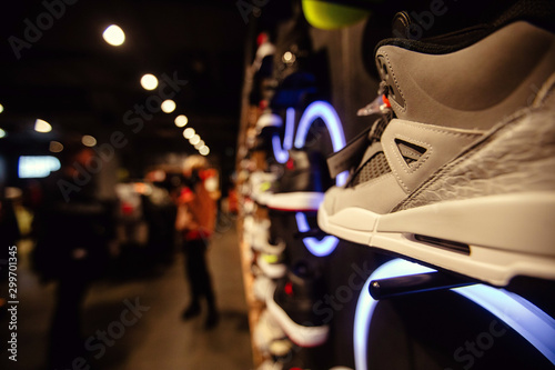 White sneakers on street window of night city decorated with illumination and neon lights