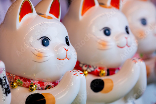 A group of ceramic Japanese lucky cats in the display cabinet (subtitle: Lucky Cat, Jin Yun Laifu) © wu shoung
