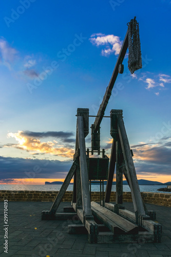 Alghero, sunset view of the Alghero old town quarter with historic defense walls, fortifications and catapult construction, Sardinia -Italy