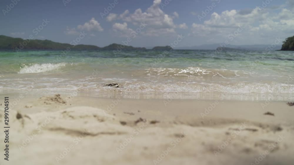 Sea calmly waving onto tropical sandy beach - close - slowmotion - pan Sea calmly waving onto tropical sandy beach - close - slowmotion - pan