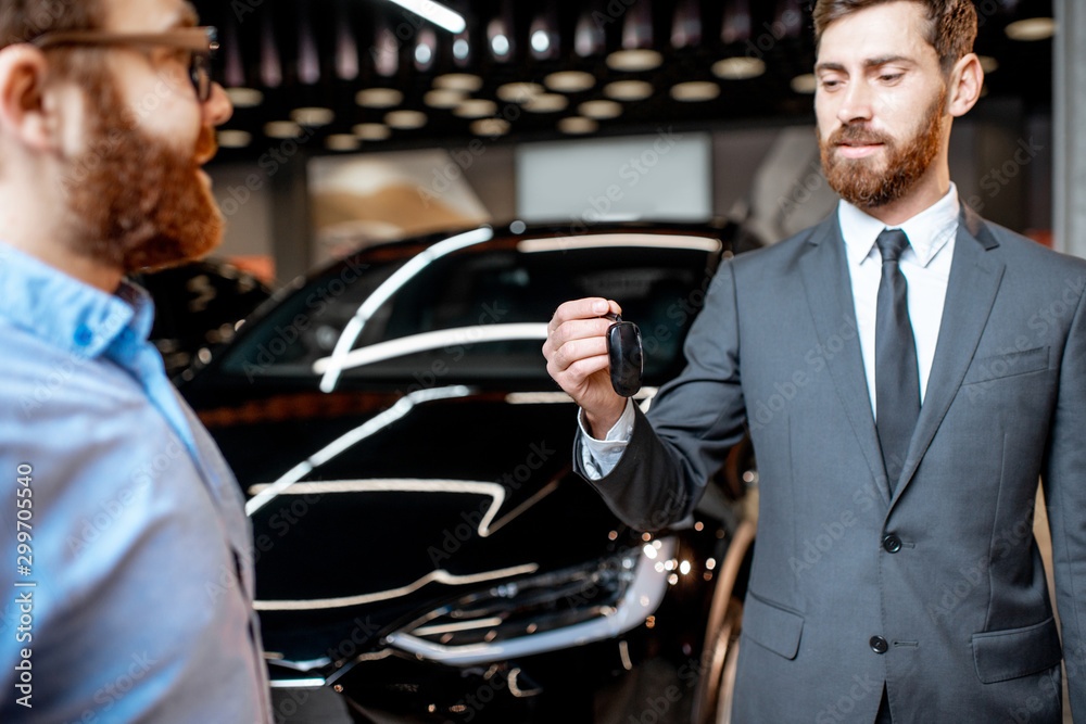 Client with a salesman at the showroom with electric cars Client with a salesman at the showroom with electric cars