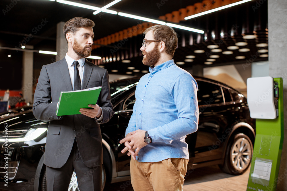 Sales consultant with a client at the car dealership Sales consultant with a client at the car dealership