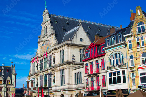 Ghent, Belgium; 10/26/2019: Nederlands Toneel Gent (NTGent or NTG), a famous theatre in Sint-Baafsplein square, with traditional colorful belgian houses during a sunny day