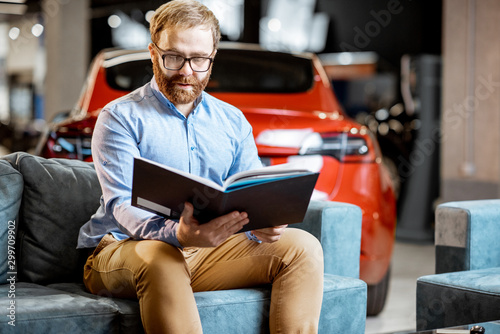 Man with catalog in the car dealership