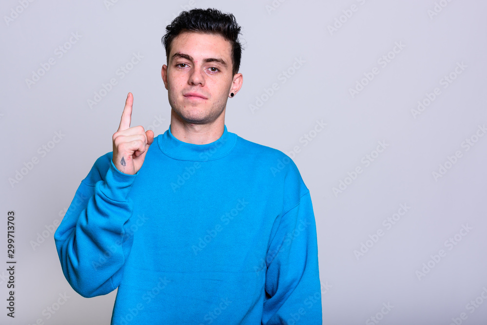 Studio shot of young handsome man isolated against white background