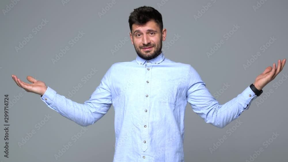 Young man with raised hands isolated on gray background Young man with raised hands isolated on gray background
