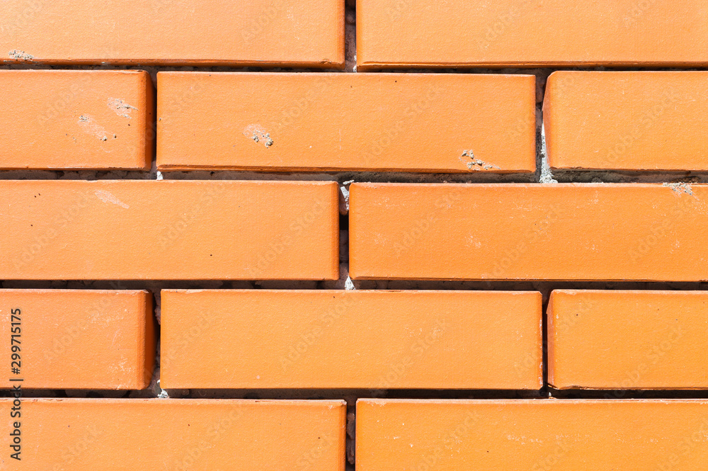 Fototapeta premium Textured background new brickwork close-up orange brick