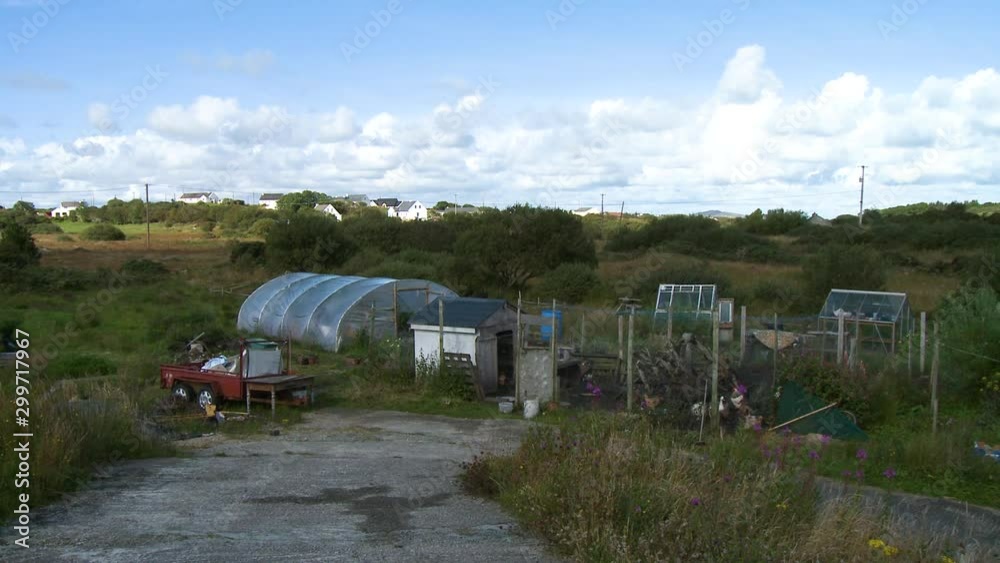 Steady, wide shot of a greenhouse and farm next to a neighborhood. Steady, wide shot of a greenhouse and farm next to a neighborhood.