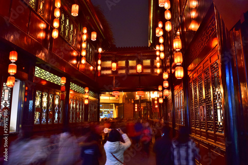 Young Woman Takes a Photo of Chinese Lanterns Hanging from Old Traditional Buildings Along Chengdu's Famous Jinli Street at Night - Chengdu, China (Summer)  photo