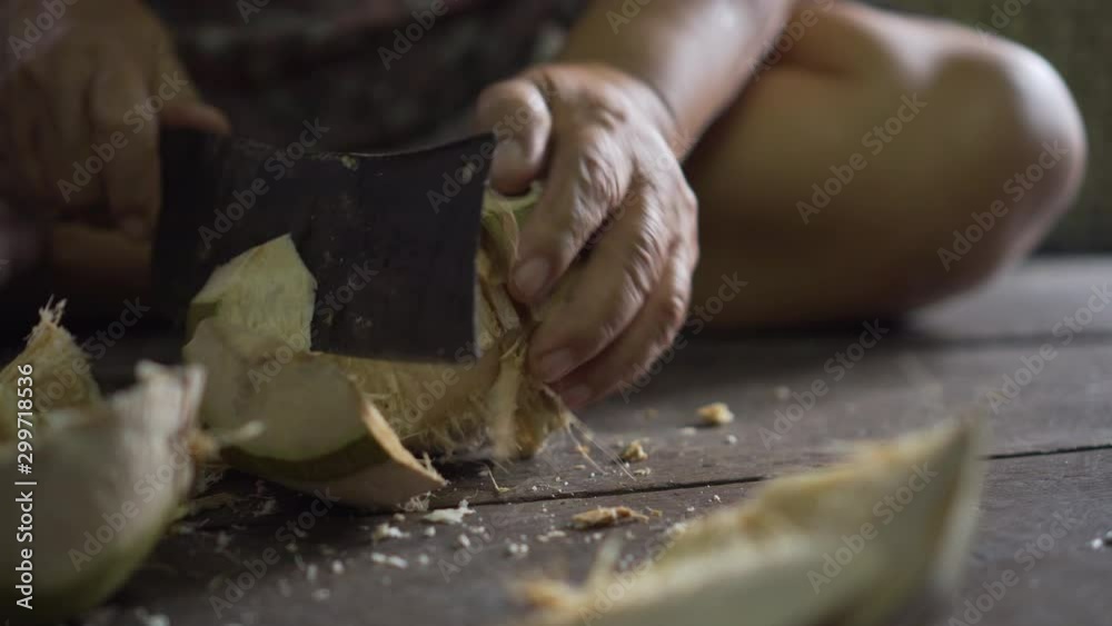 Old asian lady using big knife for chopping a coconut. Thailand. Old asian lady using big knife for chopping a coconut. Thailand.