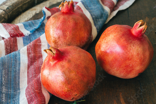 Pile of ripe  pomegranate on wooden backgfround photo