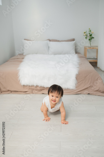 cute smiling toddler baby girl crawling on the floor