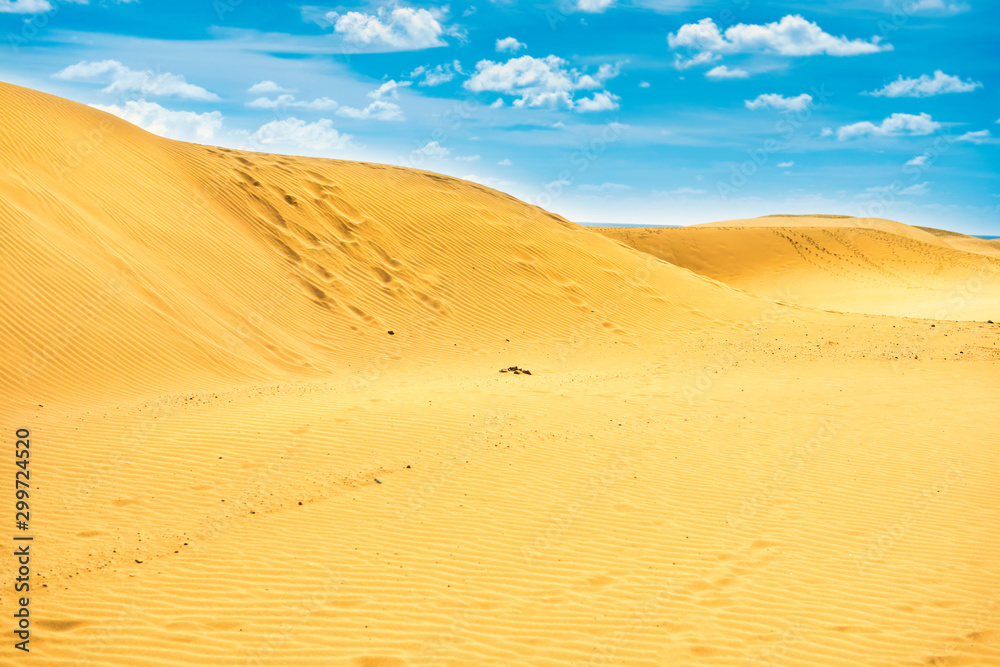 Desert with sand dunes and clouds on blue sky. Landscape of natural reserve Maspalomas Dunes. Gran Canaria, Spain