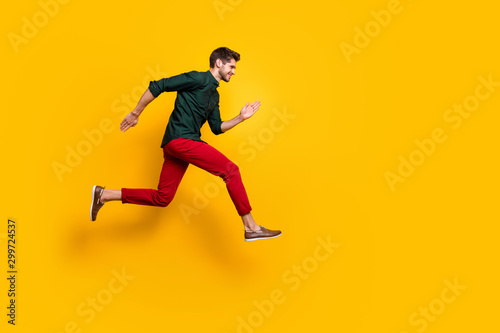 Full body profile side photo of positive cheerful funky guy hear about wonderful black friday sales jump run want be first wear casual style outfit isolated over yellow color background