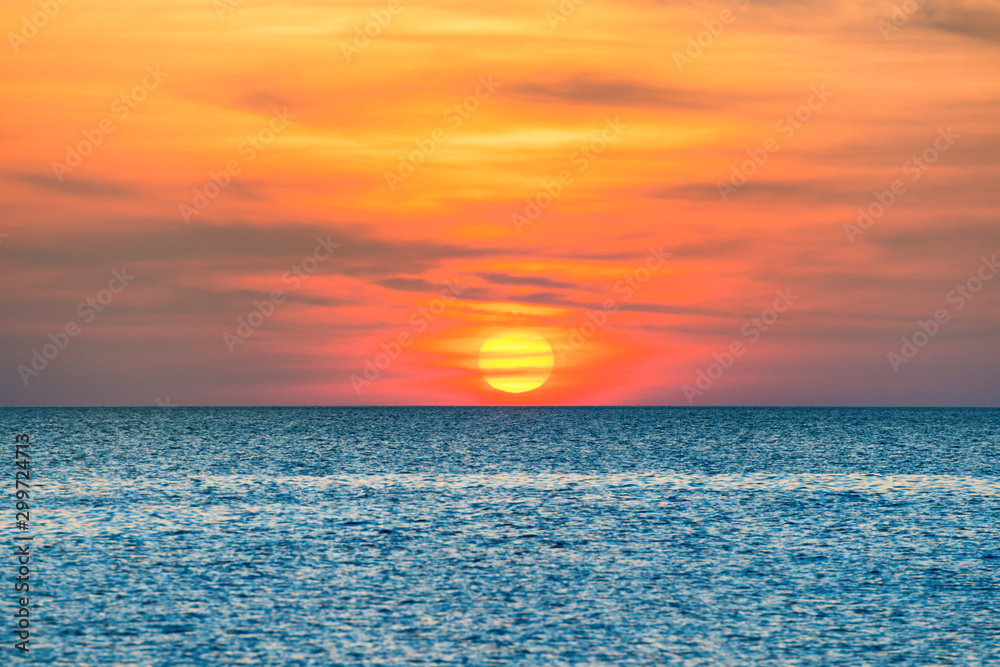 Nature landscape with beautiful dramatic orange sunset over blue wave sea