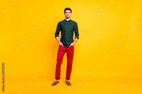 Full length body size photo of serious confident executive standing with hands in pockets wearing shoes isolated over yellow vivid color background
