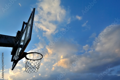 Silhouette of basketball hoop and clouds in blue sky backgroun
