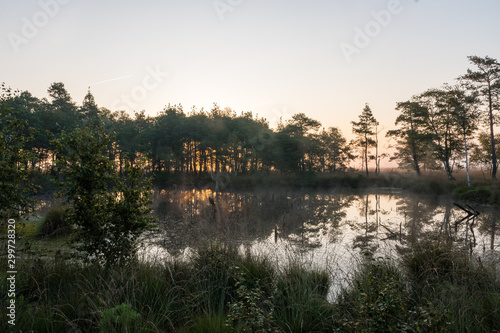 A quiet lake in a moor with soft light before sunrise