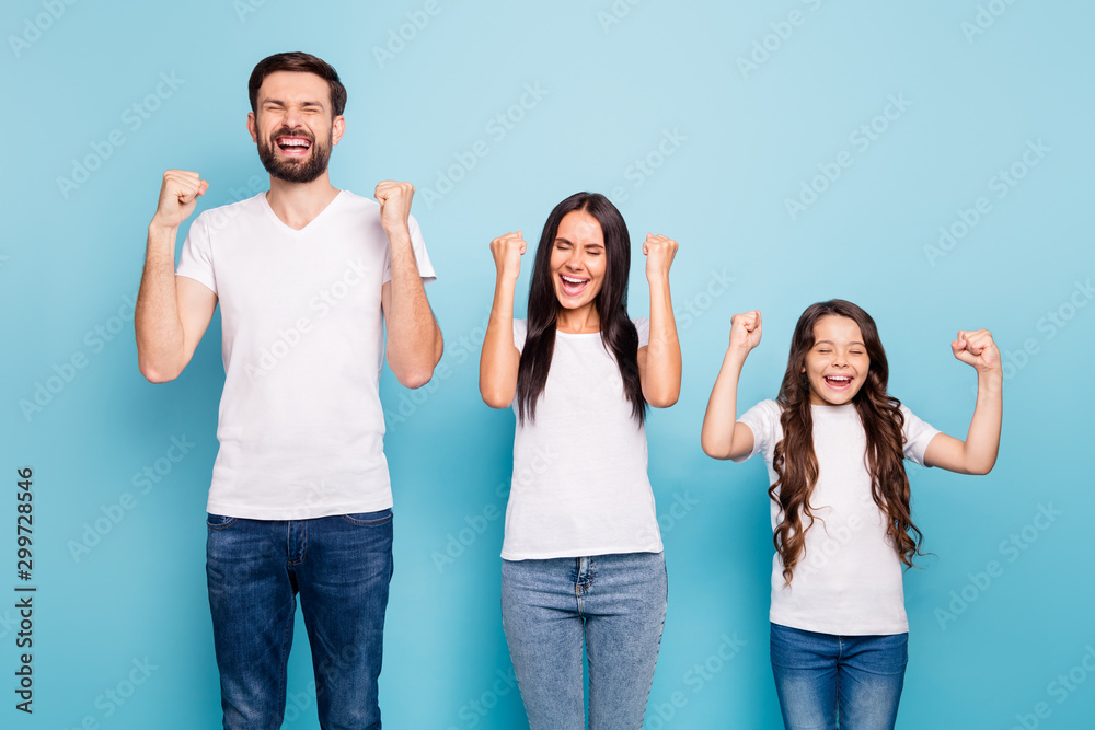 Portrait of delighted mommy daddy girl with brunette hair celebrate triumph reaise fists scream yeah wear white t-shirt denim jeans isolated over blue color background - obrazy, fototapety, plakaty 
