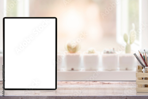 Mockup blank screen tablet and wooden box of pencil on wooden top table.