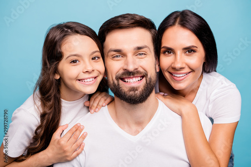 Close up photo of cheerful lovely three people piggyback lean shoulder enjoy vacation wear white stylish t-shirt isolated over blue pastel color background