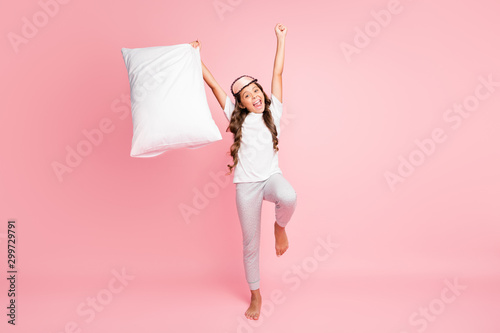 Full length body size photo of cheerful positive hispanic emotional girl raising her hands with pillow in wearing t-shirt pants isolated pastel color background