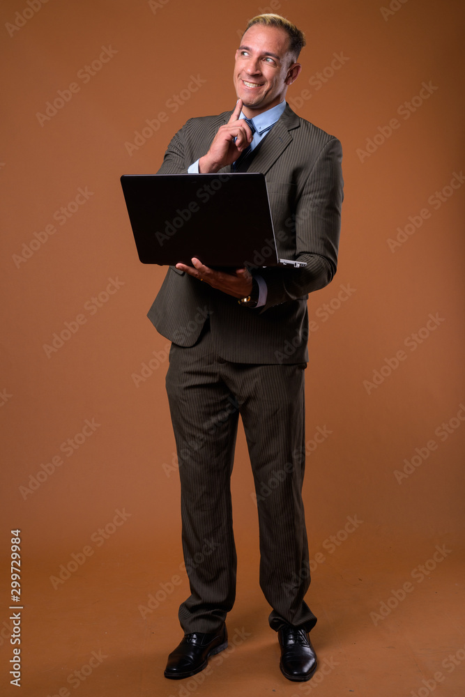 Full body shot of businessman using laptop computer Full body shot of businessman using laptop computer