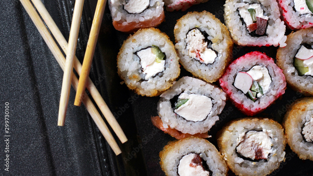Salmon sushi rolls on black background, japanese food top view Salmon sushi rolls on black background, japanese food top view