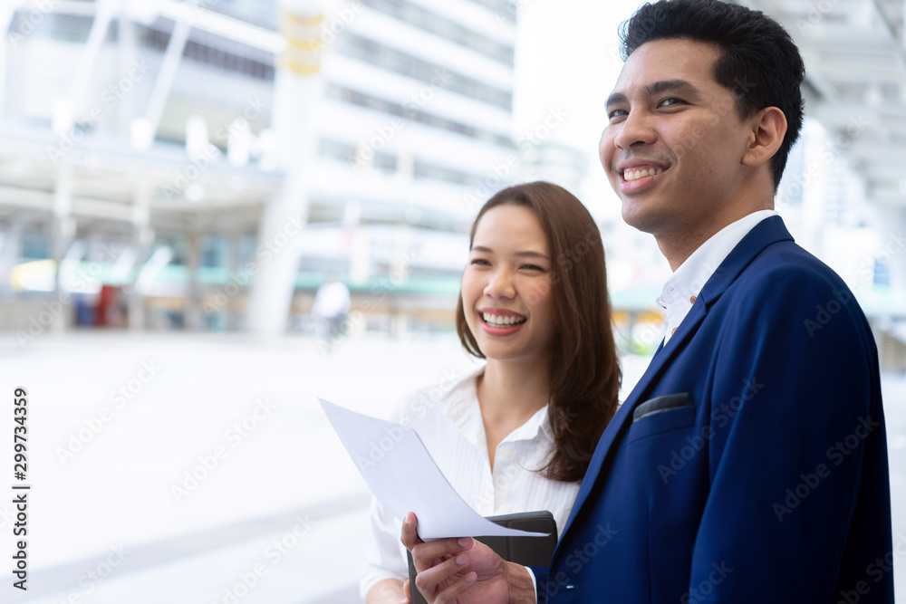 © chinnarach - close up group of businesspeople teamwork looking forward together with happiness feeling after completed goal at outside city building background for successful job concept