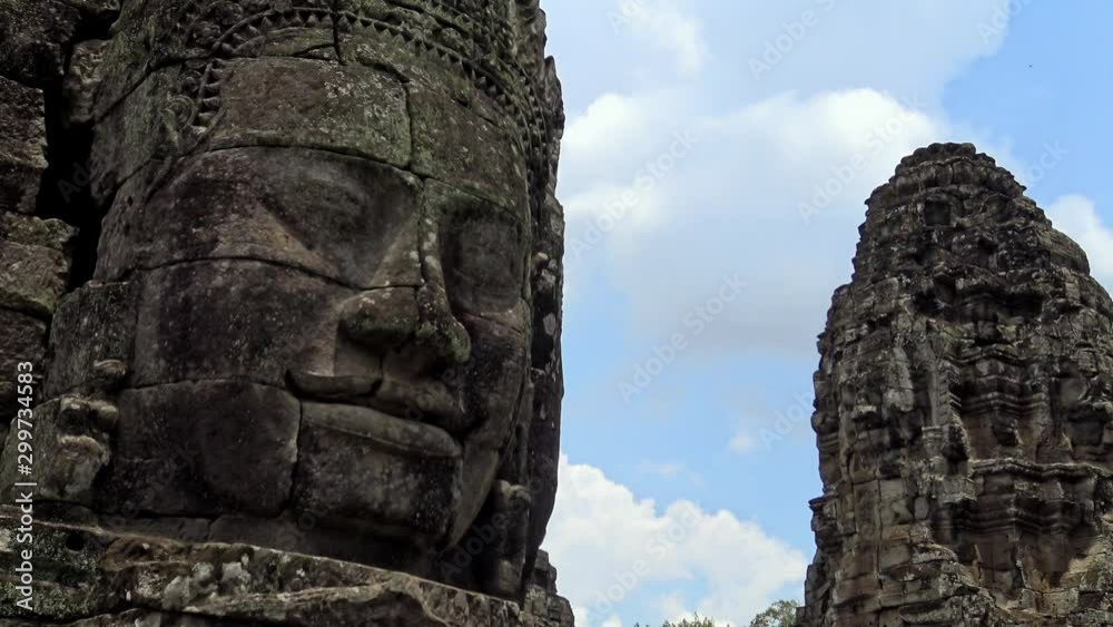 4K, Ancient stone faces statue of Bayon temple. Angkor Thom is a popular tourist attraction of Asia with a richly decorated Khmer temple. Famous landmark of Cambodia with serenity stone faces.-Dan